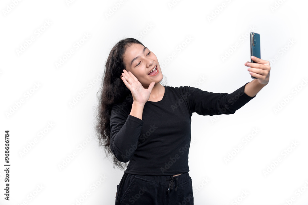 Smiling Asian woman in black t-shirt doing video call pose while waving palm saying hi isolated over white background. Smiling Asian woman in black t-shirt doing video call pose while waving palm saying hi isolated over white background.