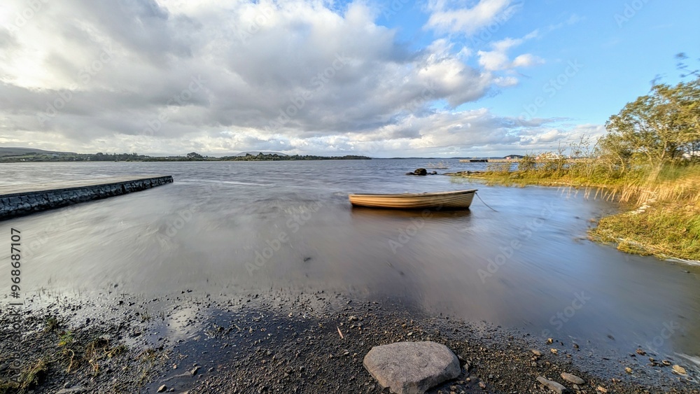 Beautiful lakeside landscape scenery, old wooden fishing boat by Oughterard pier on Corrib lake, Galway, Ireland, nature background