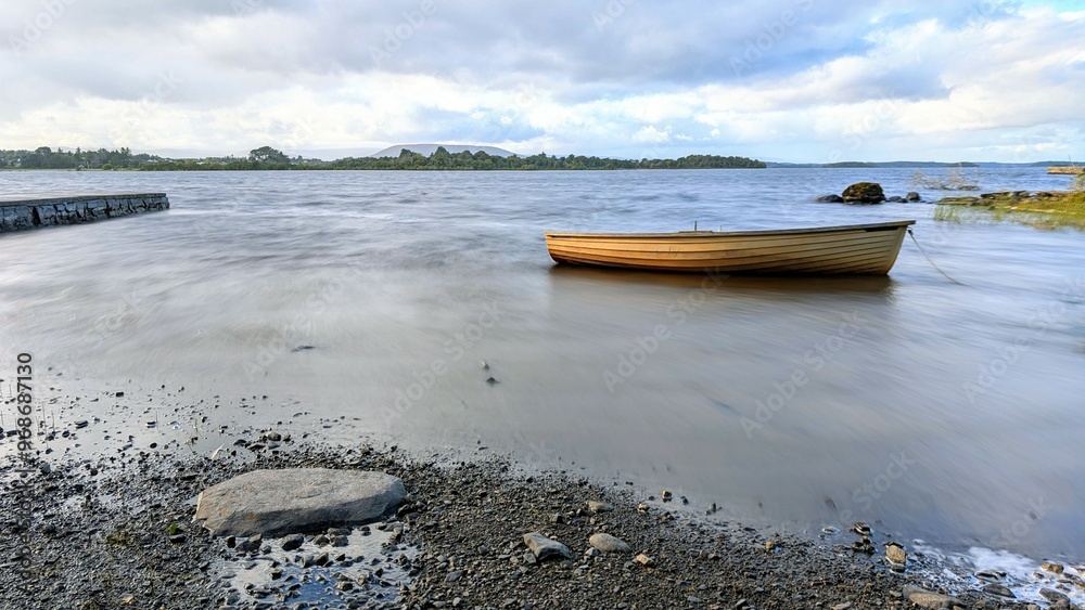 Beautiful lakeside landscape scenery, old wooden fishing boat by Oughterard pier on Corrib lake, Galway, Ireland, nature background