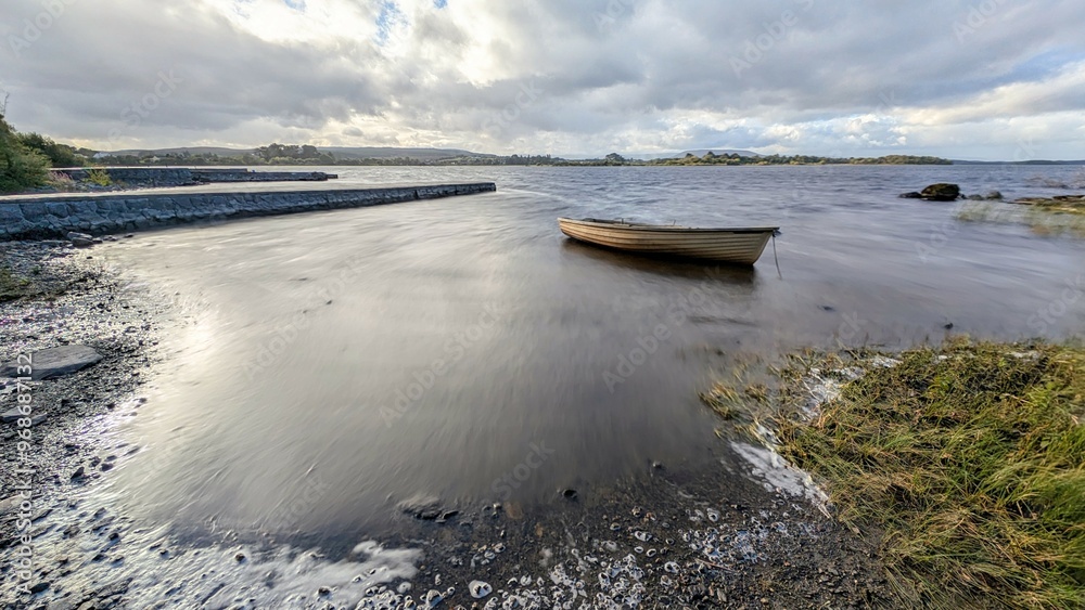 Beautiful lakeside landscape scenery, old wooden fishing boat by Oughterard pier on Corrib lake, Galway, Ireland, nature background