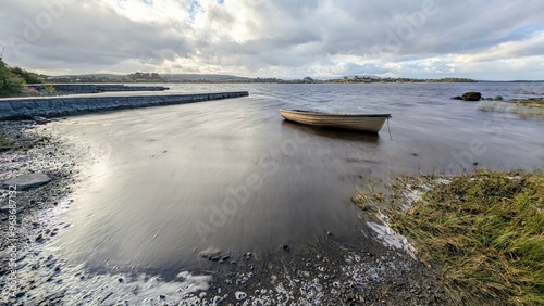 Beautiful lakeside landscape scenery, old wooden fishing boat by Oughterard pier on Corrib lake, Galway, Ireland, nature background photo