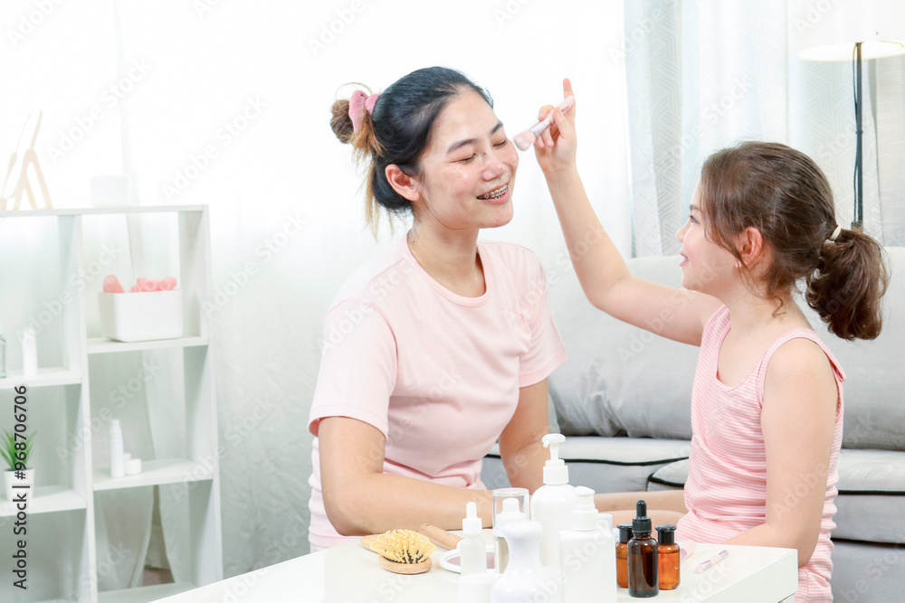 Happy family.Mother teaches her daughter how to use makeup. Mother and daughter are .sitting in the living room. Little girl holding a brush for powder. Happy family.Mother teaches her daughter how to use makeup. Mother and daughter are .sitting in the living room. Little girl holding a brush for powder.