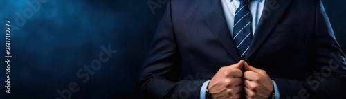 Businessman adjusting tie in a formal suit. Professional attire showcases confidence and elegance against a dark background.