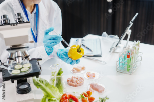 Two female researchers in the lab work at a desk on plant genetic modification for food, meat, and vegetables, utilizing advanced genetic engineering technology to enhance crops and animal feed.