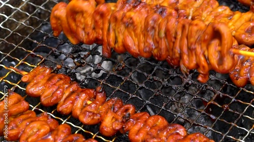 slow motion of flipping chicken intestine on the grill; a famous Filipino street food 