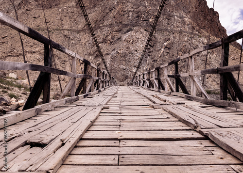 A typical Pakistan bridge is built over a rocky mountain photo