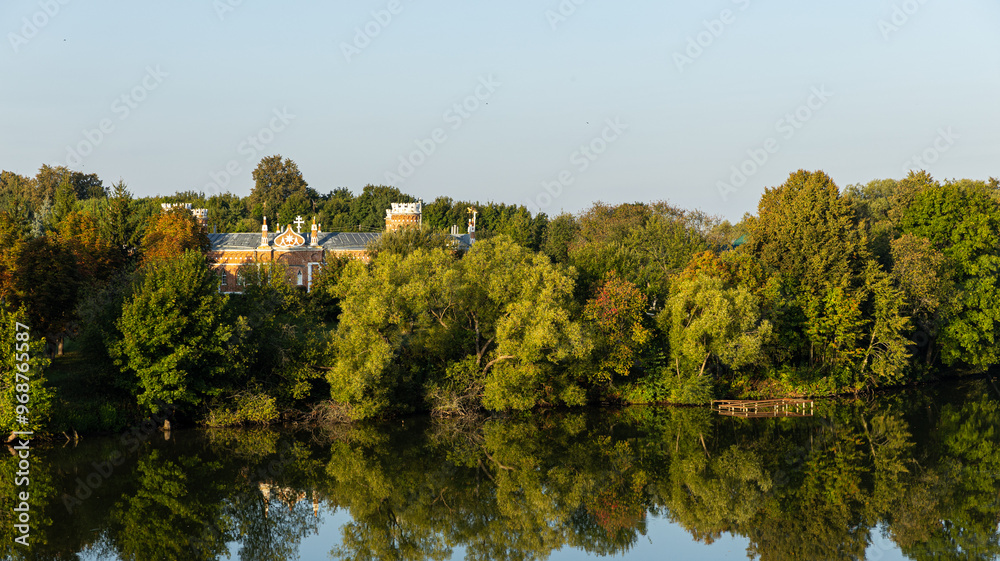 A vast expanse of water encircled by lush trees and various buildings A vast expanse of water encircled by lush trees and various buildings