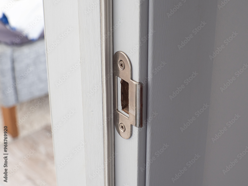  Close-up view of a stainless steel door lock hole on a white door surface