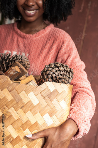 Homey woman outdoors with a basket filled with pine cones photo