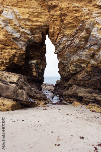 Arco excavado en la roca durante miles de años por la fuerza del agua en una playa de Tapia de Casariego, Asturias, España