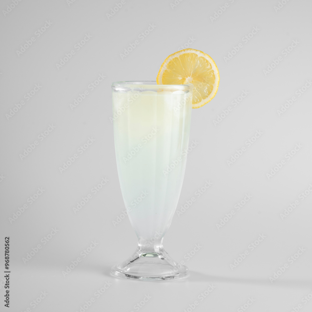 Refreshing lemonade in a clear glass with a lemon slice garnish. Minimalistic drink presentation on a white background. Refreshing lemonade in a clear glass with a lemon slice garnish. Minimalistic drink presentation on a white background.