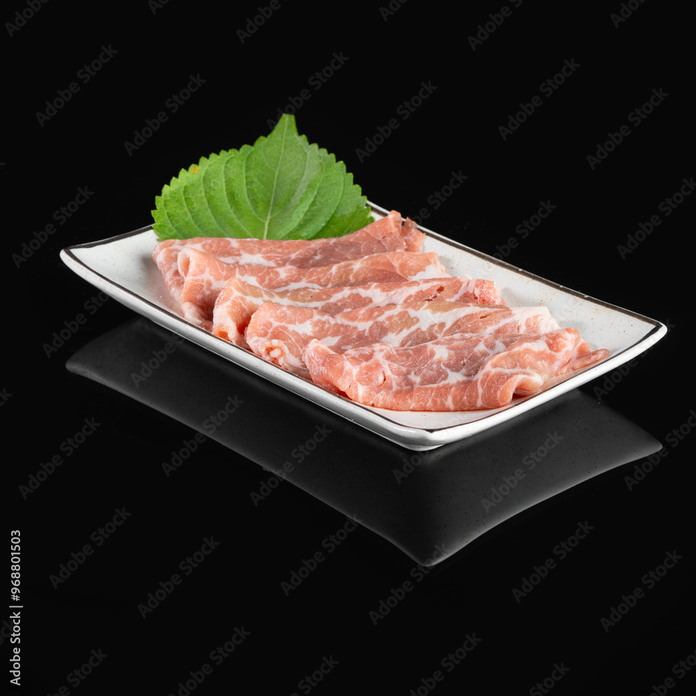 Fresh pork belly slices neatly arranged on a white rectangular plate with a leaf garnish. Perfect for recipes and culinary presentations. Fresh pork belly slices neatly arranged on a white rectangular plate with a leaf garnish. Perfect for recipes and culinary presentations.