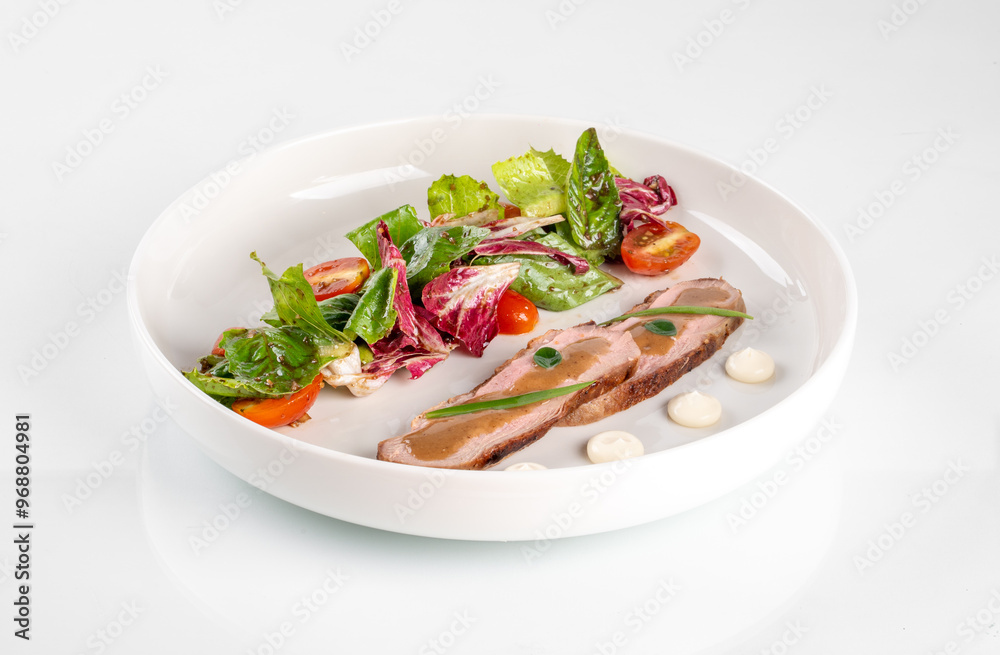 Gourmet dish with sliced meat and fresh salad greens presented on a white plate, minimalistic fine dining presentation. Gourmet dish with sliced meat and fresh salad greens presented on a white plate, minimalistic fine dining presentation.