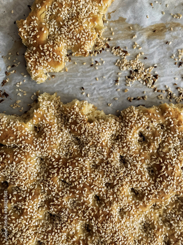 Pieces of baked crispy flatbread covered in sesame seeds.