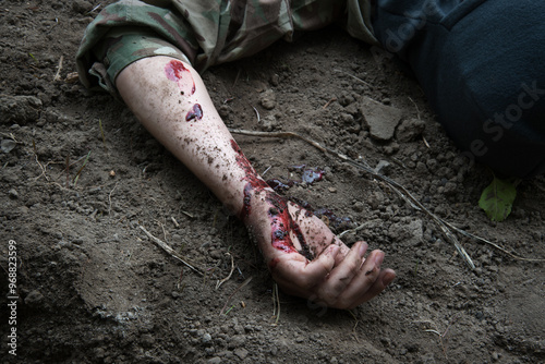 Hand of a wounded soldier on the ground