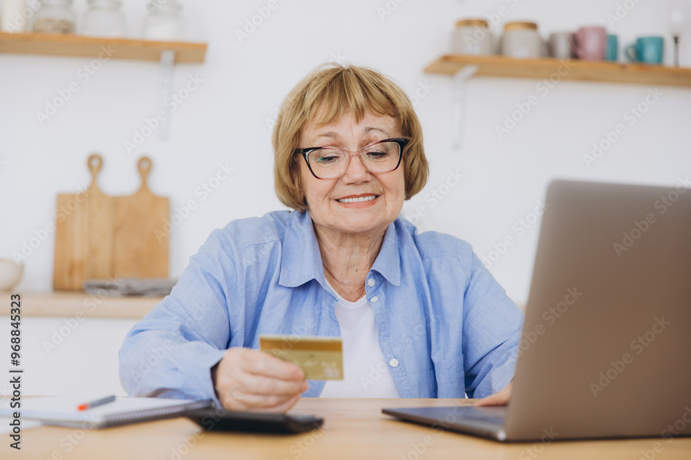 One elderly senior woman grandmother sit at home use credit or debit card for online shopping browse internet stores buying stuff on discount sale real people copy space use laptop computer One elderly senior woman grandmother sit at home use credit or debit card for online shopping browse internet stores buying stuff on discount sale real people copy space use laptop computer