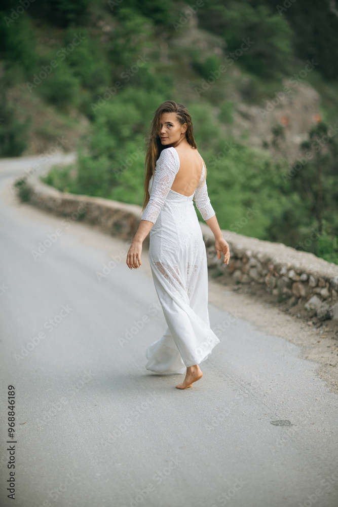 A woman in a white dress is walking down a road A woman in a white dress is walking down a road