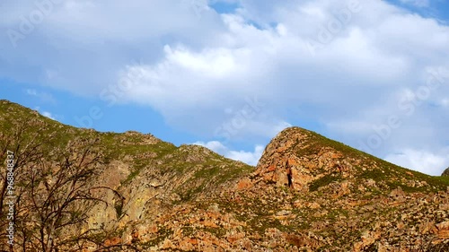 Time-lapse of white clouds in blue sky moving over rugged Langeberg mountains photo