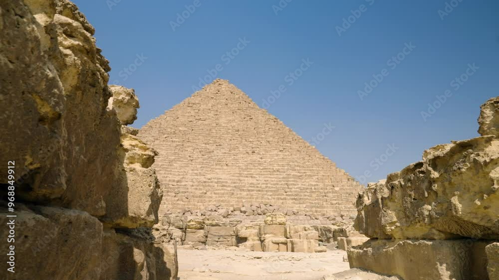 Limestone Blocks Of Giza Plateau With Great Pyramid Complex In The Background Near Cairo, Egypt. Close-up Parallax Shot Limestone Blocks Of Giza Plateau With Great Pyramid Complex In The Background Near Cairo, Egypt. Close-up Parallax Shot