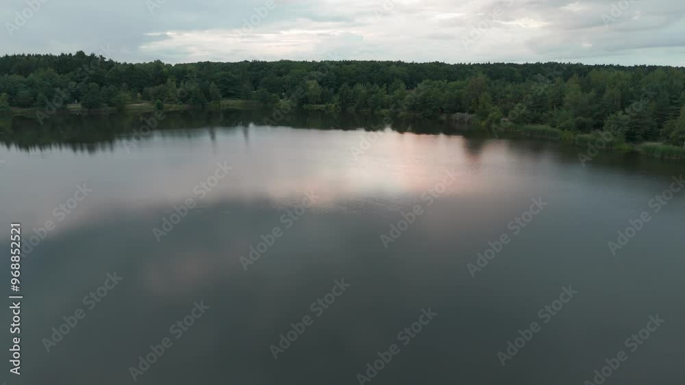 Cloudy afternoon on a still lake surrounded by deep lush forest in Poland Cloudy afternoon on a still lake surrounded by deep lush forest in Poland