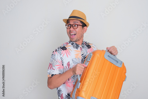 A man carrying a luggage with excited expression. Travel concept photo