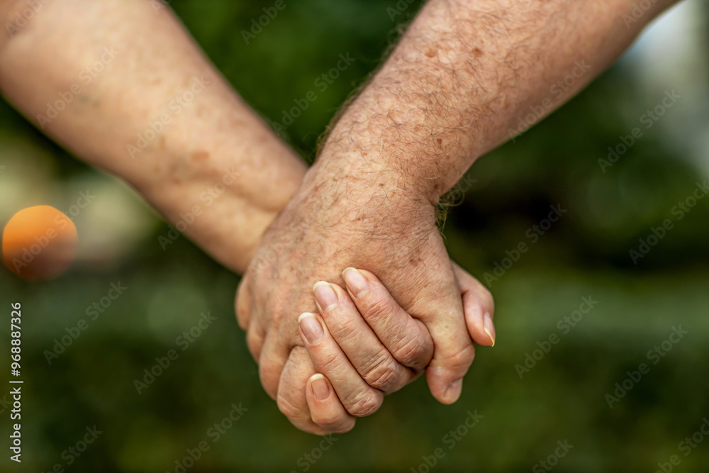 Close-up: the hands of elderly spouses holding each other's hands, feeling the love and strong affection of 50 years of marriage Close-up: the hands of elderly spouses holding each other's hands, feeling the love and strong affection of 50 years of marriage
