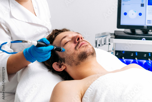 Man undergoing a facial peeling procedure in a beauty clinic, close-up. Rejuvenating hydro-air skin cleansing treatment. Perfect for promoting advanced skincare solutions.
