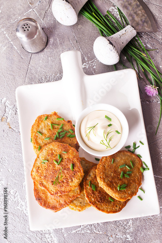 Fried potato pancakes with white sauce on plate