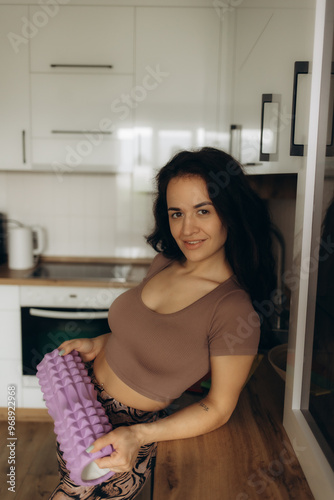 woman in the kitchen with a yoga roller