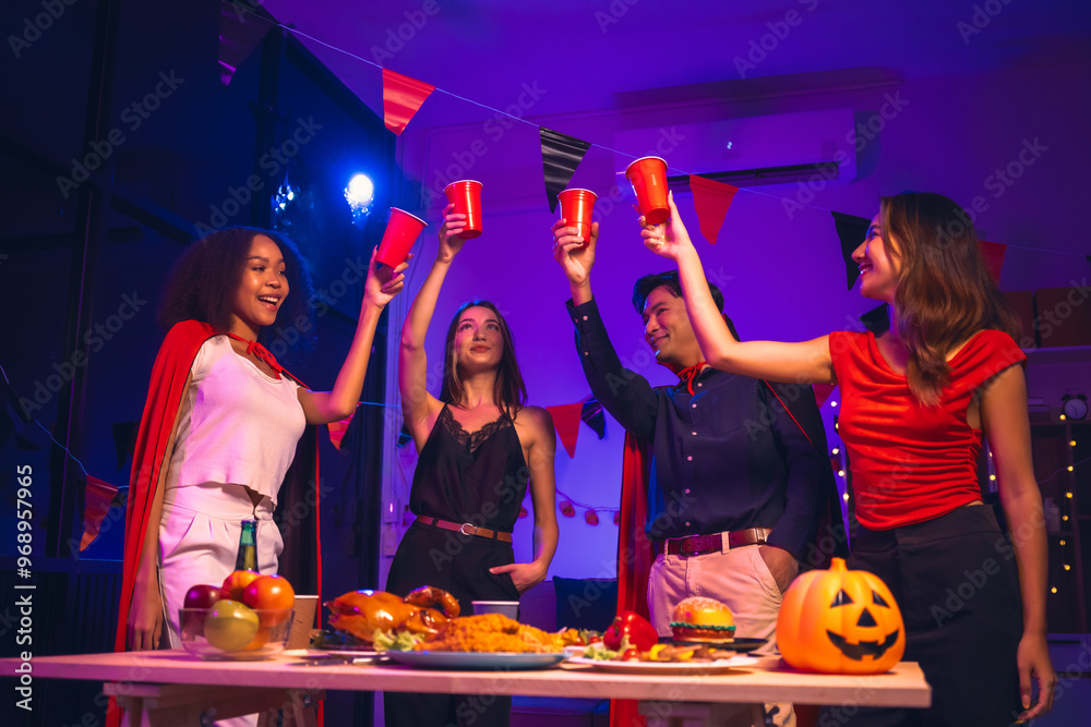 Asian friends, middle-aged man and young woman, enjoy Halloween office party with vampire costumes, fried chicken, grilled food, grape wine, champagne, RGB lights, festive decorations in the night.