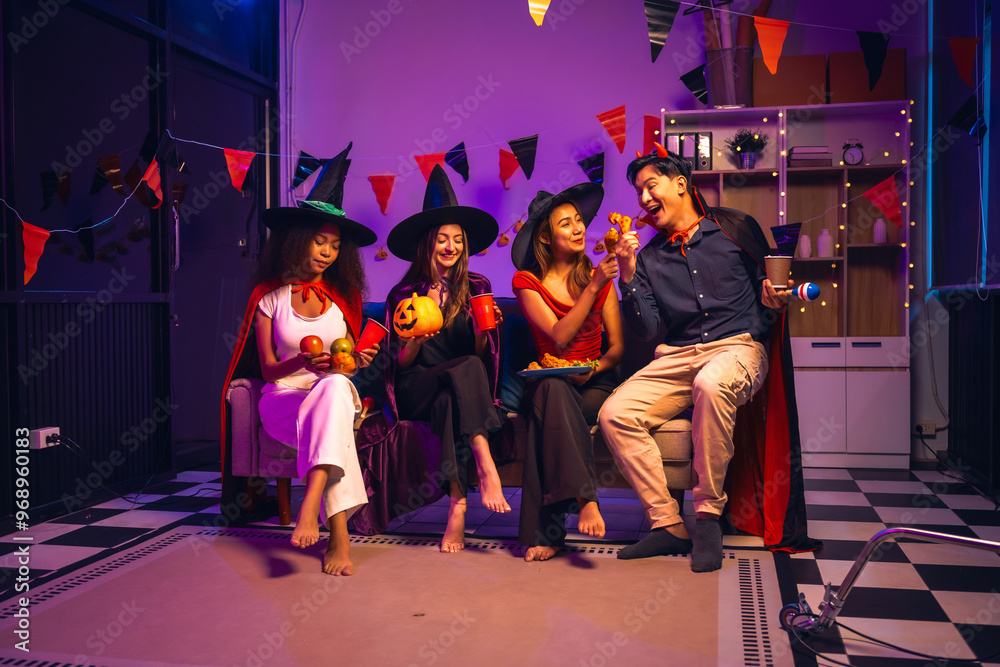 Asian friends, middle-aged man and young woman, enjoy Halloween office party with vampire costumes, fried chicken, grilled food, grape wine, champagne, RGB lights, festive decorations in the night. Asian friends, middle-aged man and young woman, enjoy Halloween office party with vampire costumes, fried chicken, grilled food, grape wine, champagne, RGB lights, festive decorations in the night.