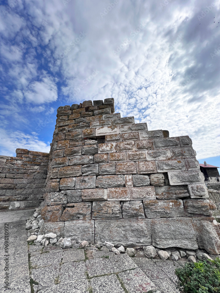 a adobe and stone wall with picturesque house a adobe and stone wall with picturesque house