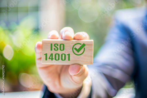 ISO 14001 Concept: Businessman Holding Block with Certification for Environmental Management Systems