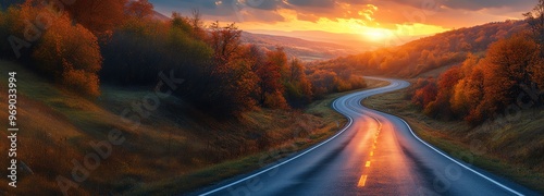 Winding road through autumn landscape at sunset, vibrant fall foliage and a scenic countryside view bathed in golden sunlight. photo