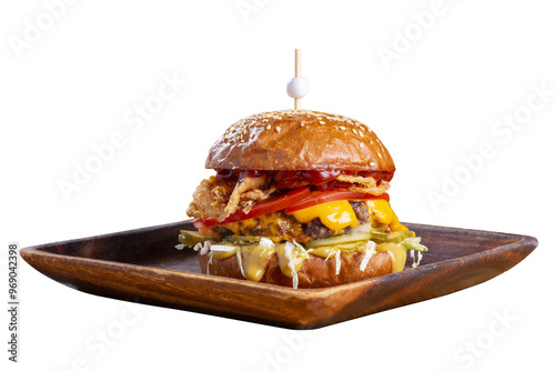 Big tasty burger with fried cutlet, cabbage salad, tomatoes and sauce on wooden plate isolated on white background.