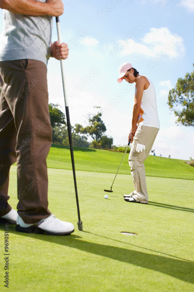 Obraz premium Hole, game and couple on golf course with club, outdoor fun and fitness on weekend morning together. Ball, woman and man on green grass for nature sports, challenge and competition with exercise