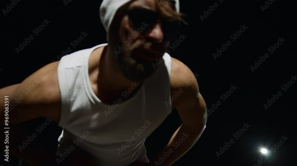 Man in white sportswear poses for the camera under the stars Man in white sportswear poses for the camera under the stars