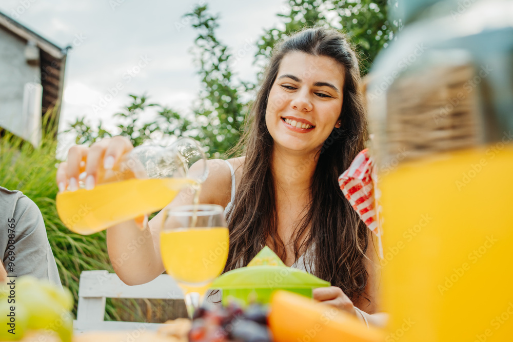 Group of three friends or family having picnic in backyard or garden Group of three friends or family having picnic in backyard or garden