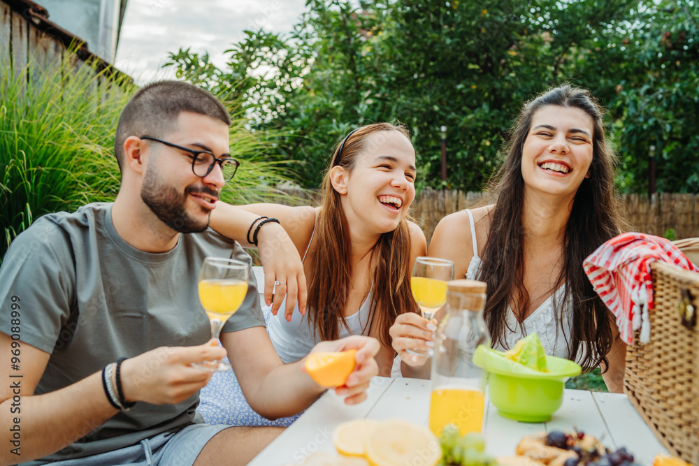 Group of three friends or family having picnic in backyard or garden Group of three friends or family having picnic in backyard or garden