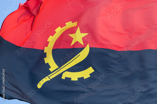 the flag of angola in the beautiful sky flutters the fabric of the national flag of angola. great for news