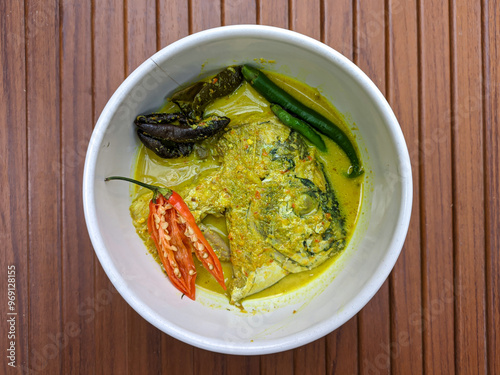 Semar fish head curry. Culinary delights with Indonesian spices. Semar fish (Mene maculata) cooked in yellow curry sauce with a spicy and savory taste typical of Minangkabau. photo