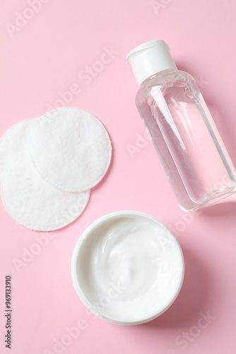 Micellar cleansing water, cream and cotton pads on a color background, top view. Flat lay.