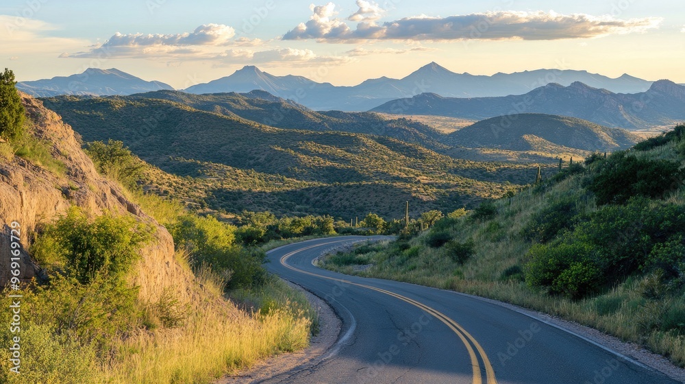 Naklejka premium A scenic overlook with a well-maintained mountain road winding through the landscape, offering stunning views of distant mountain ranges