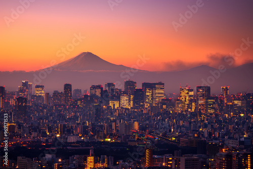 A breathtaking aerial view of Tokyo at dusk, showcasing the city's vibrant lights and skyscrapers against the backdrop of Mount Fuji