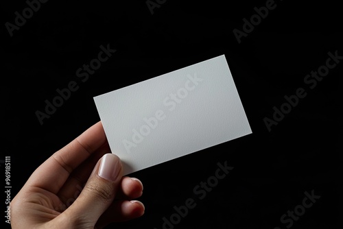 A blank business card held in a hand, ready for customization or printing, isolated on a dark background.