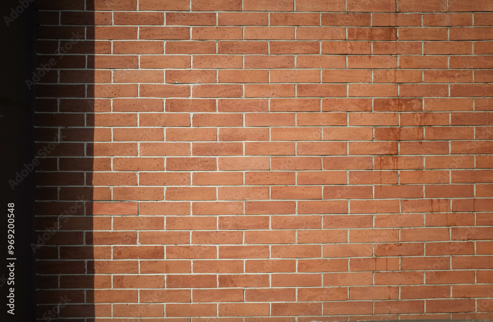 Red brick wall summer background with shadows. Brick wall copy space background.