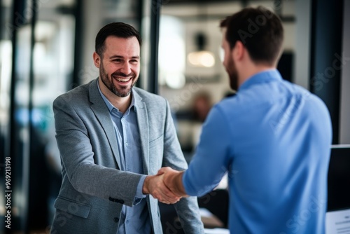 Smiling Man in Suit Shakes Hands in an Office