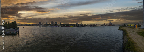 A panoramic view of Hamburg's skyline featuring the harbor and the Elbe River at dusk.