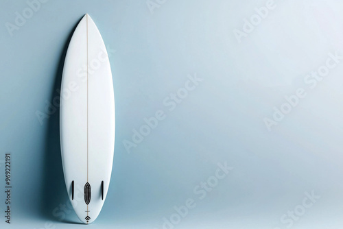 Sleek white surfboard standing against a minimalist backdrop, showcasing its elegant design and smooth finish.