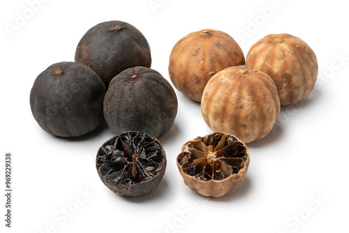 Whole and halved dried black and white limes, loomi, isolated on white background close up photo